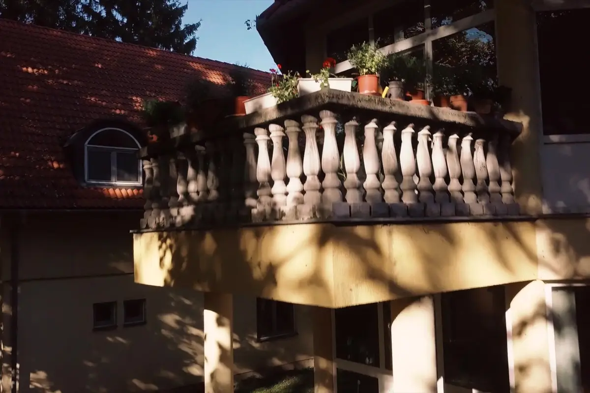 Kőkorlátos erkély virágládákkal a főbejárat fölött