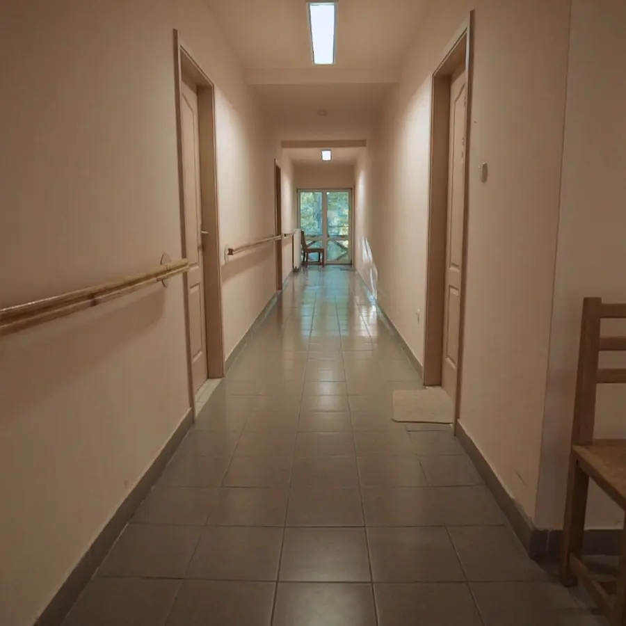 Folyosó a fal mentén végigfutó kapaszkodóval